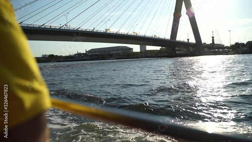 Boat sailing on Bangkok river Chao Phraya in slow motion with view of the bridge