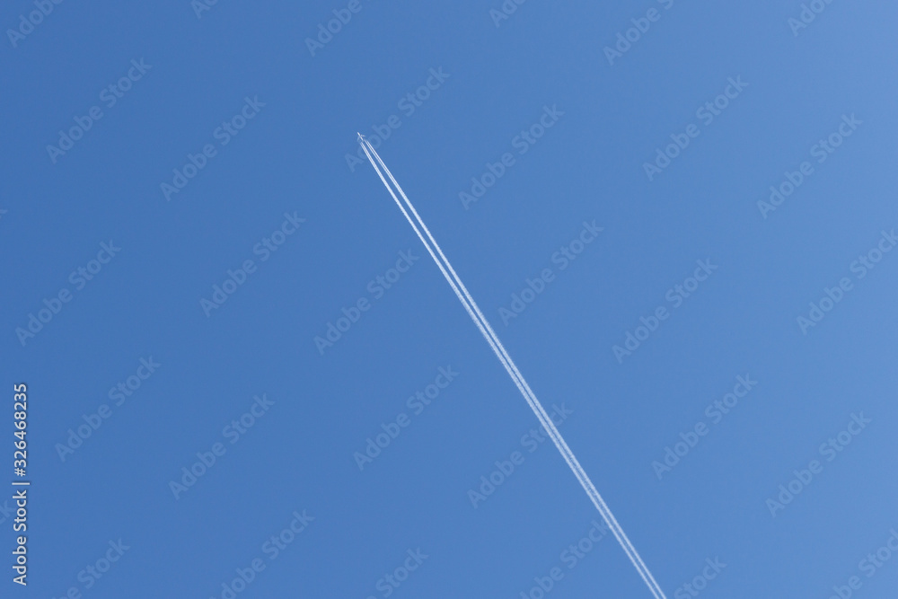 Trail of an airplane piercing the blue sky Trail of an airplane piercing the blue sky