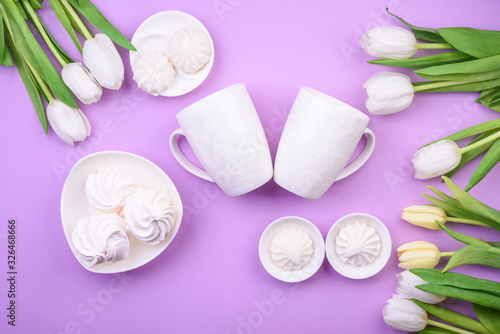  white tulips and white mug with tea, sweets on pink background. Flat lay. Valentine's day, Mother's day, international women day