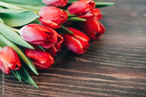 Fototapeta Naklejka Na Ścianę i Meble -  Bouquet of red tulips on a wooden background