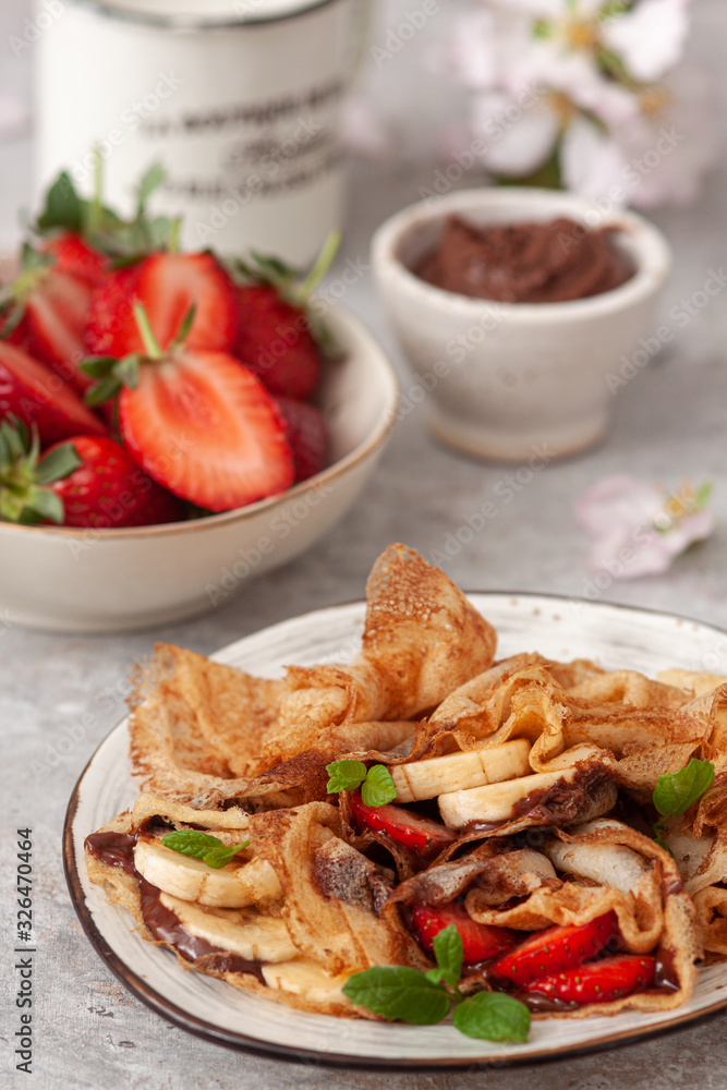 Crepes stuffed with chocolate spread , banana and strawberries Crepes stuffed with chocolate spread , banana and strawberries