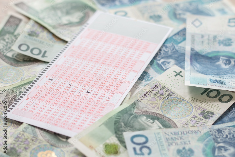 Wygrana w lotto. Pieniądze leżą na stole a kupon ze szczęśliwymi liczbami leży na gotówce.