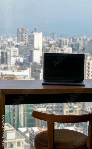 Laptop at table on the 21st floor with a beautiful view of city. Photo taken in Beirut, Lebanon