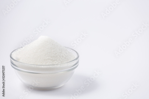 Brown sugar in a round glass cup on a white background, healthy sugar. Used for cooking or desserts.