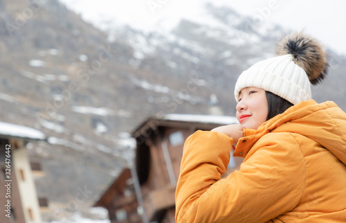 An Asian woman and her family are enjoying a winter snowy vacation and doing family activities in Zermatt Matterhorn in Switzerland.
