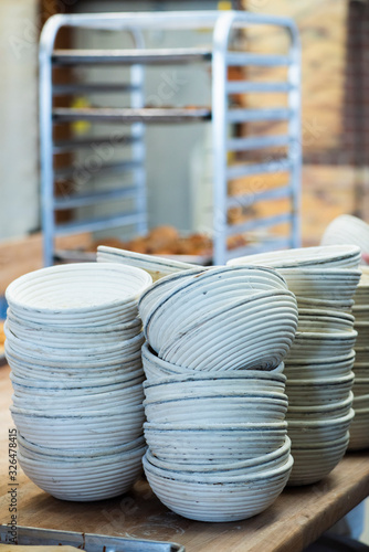 stacks of empty proofing baskets, banneton basket, brotform, traditional bread making tools at local bakery