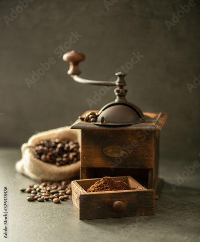 coffee grinder and beans on wooden background