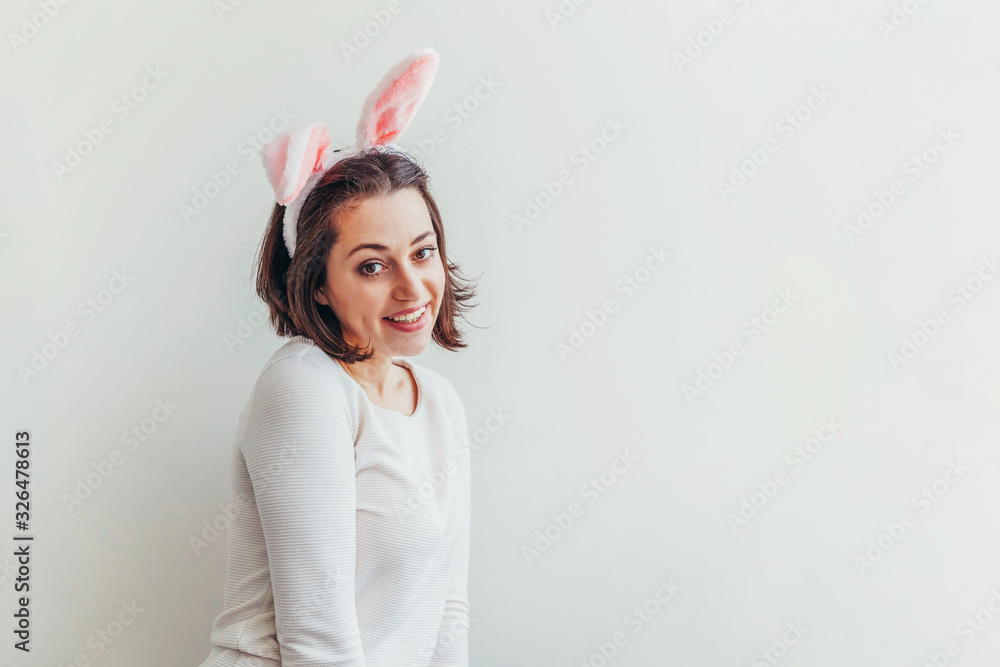 Happy Easter holiday celebration spring concept. Young woman wearing bunny ears isolated on white background. Preparation for holiday. Girl looking happy and excited having fun on Easter day