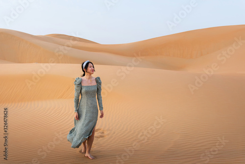 Woman walking on the desert sand dunes