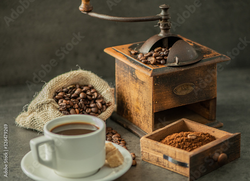 coffee grinder and beans on cement background