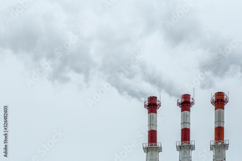 Air pollution concept. Factory smoke from pipes on a background of gray sky