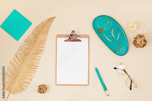 Top view over desktop with notepad, glasses and golden accessories. Home office, business woman, stylish workinf space concept. Flat lay photo