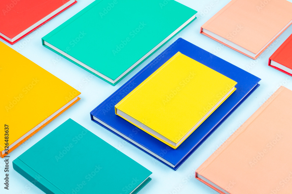 Colorful notebooks over the blue pastel background. Modern abstract working space Colorful notebooks over the blue pastel background. Modern abstract working space