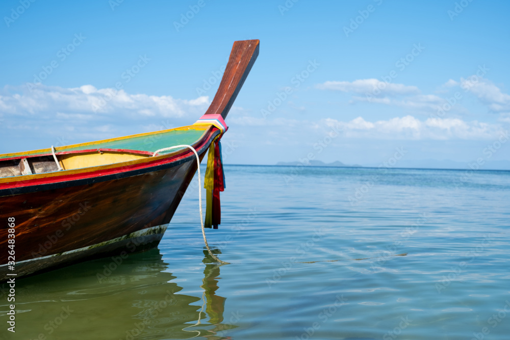 Long tail boat sailing through the blue sea with blue sky background