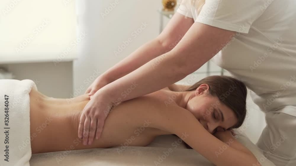 Pretty girl lying on massage table and relaxing from back massage Pretty girl lying on massage table and relaxing from back massage