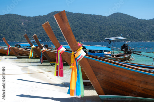 Long tail boat sailing through the blue sea with blue sky background