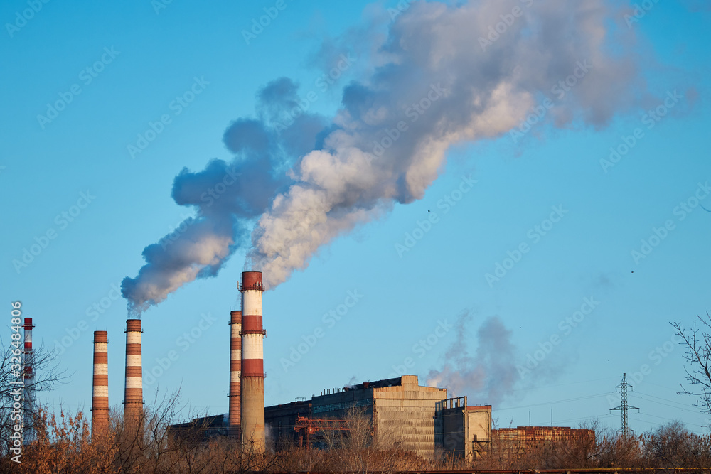 The plant emits smoke and smog from the pipes during a sunny day, pollutants enter the atmosphere. Ecological catastrophy. Harmful emissions. Chemical industry The plant emits smoke and smog from the pipes during a sunny day, pollutants enter the atmosphere. Ecological catastrophy. Harmful emissions. Chemical industry