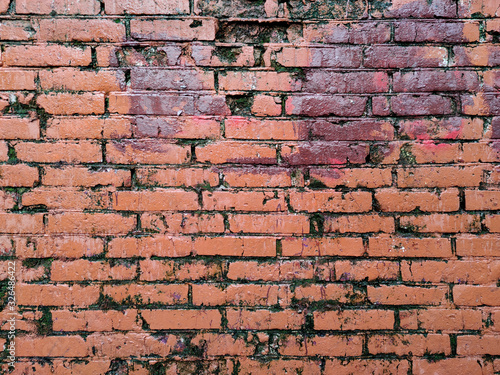 Painted brick wall of an architectural structure in red. Fashionable texture.