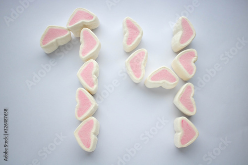 Marshmallow hearts aligned to be number fourteen for valentine's day. on white background