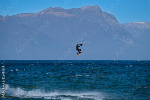 kitesurfer in the jump on a background of high mountains