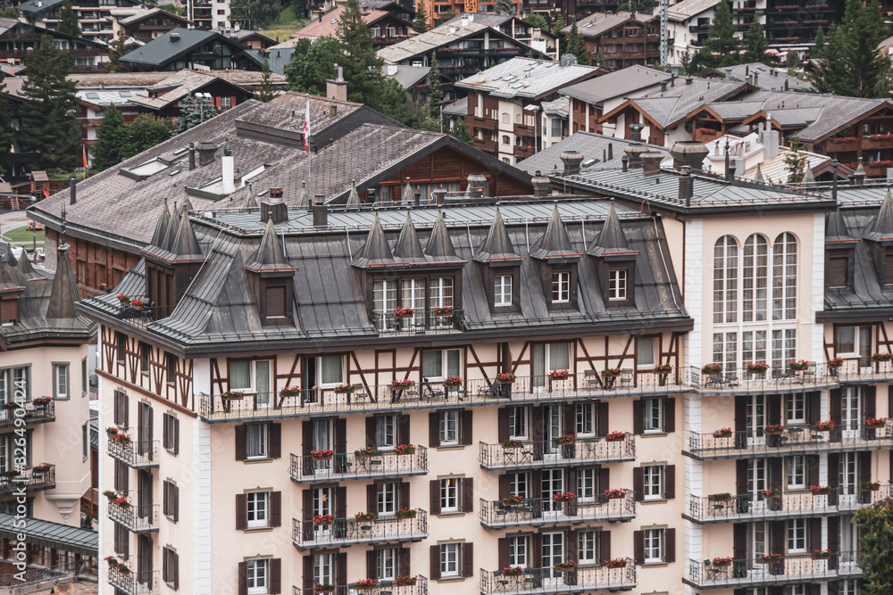 Obraz premium View of the roofs of chalets in a Swiss resort. A place preserving authentic architecture. Natural stone roofs, wooden facades