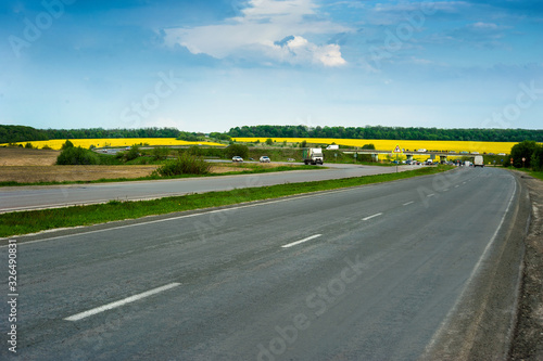 highway and yellow blooming rape field in background