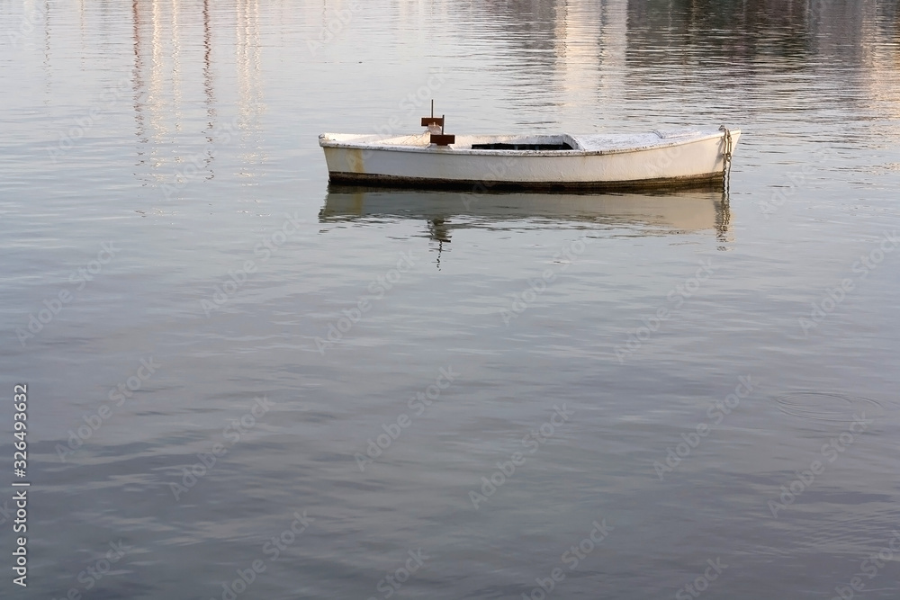 Small white fishing boat in a shallow sea. Selective focus. Small white fishing boat in a shallow sea. Selective focus.