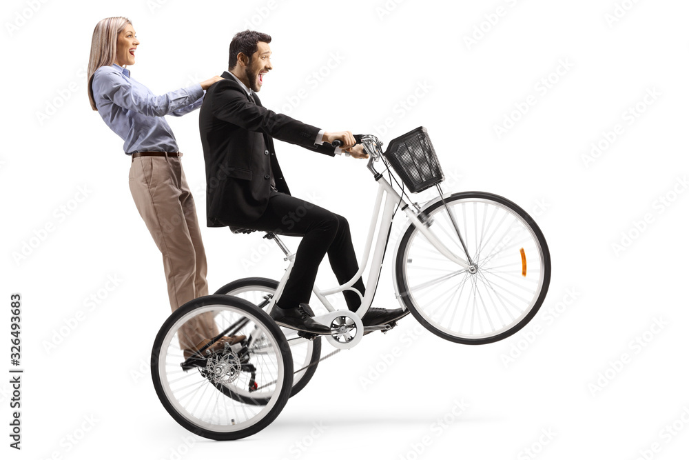 Man riding a woman on a tricycle with front wheel up Man riding a woman on a tricycle with front wheel up