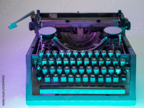 Old vintage typewriter, retro machine with white sheet of paper and typed text.