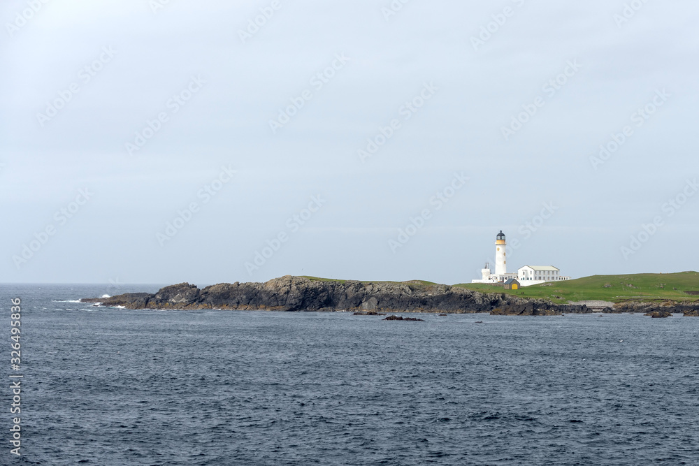 Lighthouse on small island at sea in Scotland, United Kingdom.