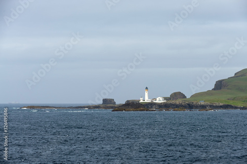 Lighthouse on small island at sea in Scotland, United Kingdom. © Alexey Seafarer