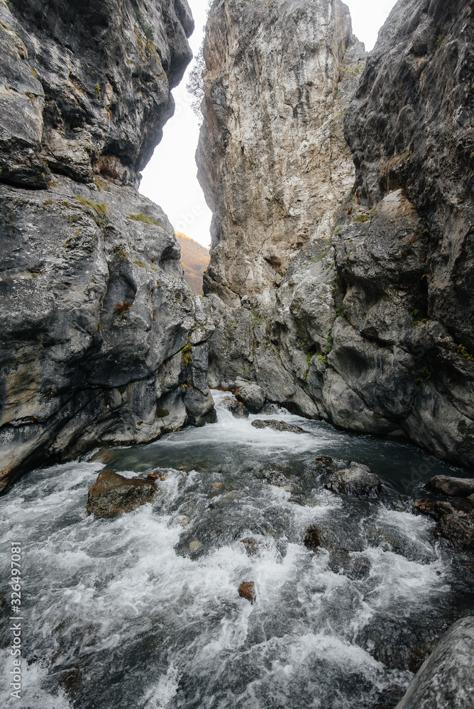 A stormy mountain river flows through a gorge of mountains. Nature. A stormy mountain river flows through a gorge of mountains. Nature.