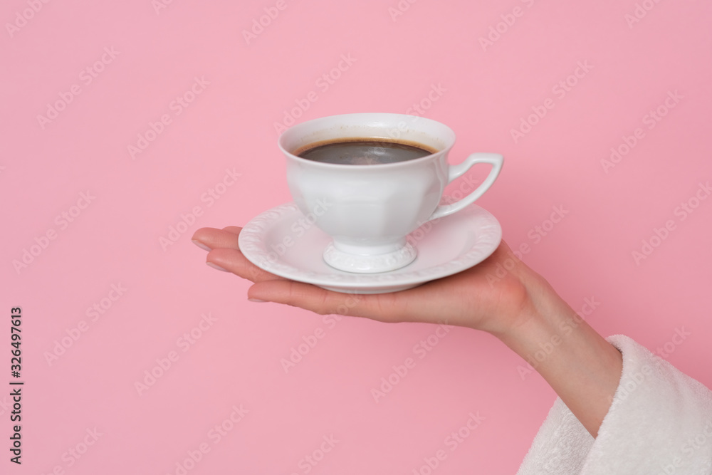 Coffe please. Female hand holding a cup of coffee isolated on pink background. Time to charge battery. Coffe please. Female hand holding a cup of coffee isolated on pink background. Time to charge battery.