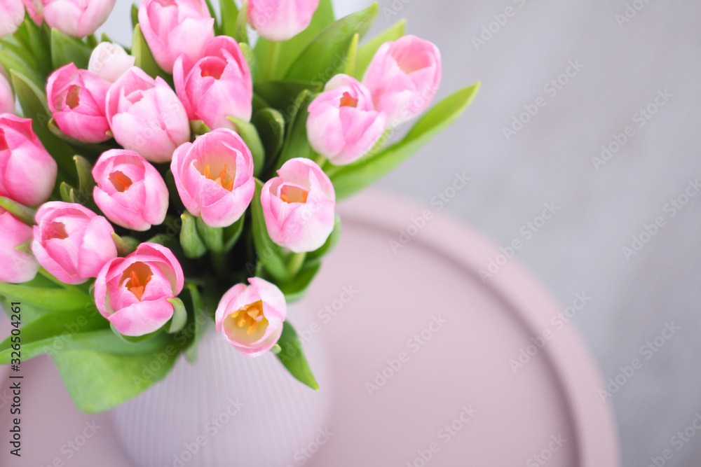 Obraz premium Pink tulips flowers bouquet in vase on table. Women, Mothers, Valentine's Day, birthday, spring greeting card. Copy space.