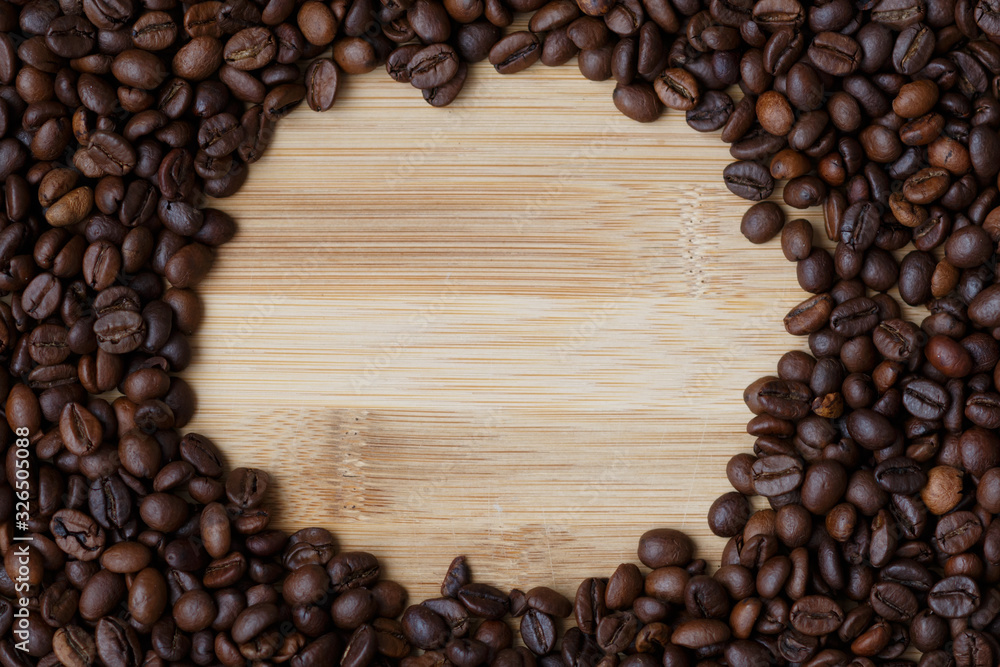 coffee beans on a light wooden table surface with an empty seat in the center coffee beans on a light wooden table surface with an empty seat in the center