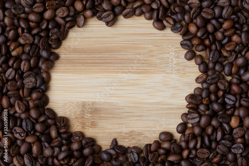coffee beans on a light wooden table surface with an empty seat in the center