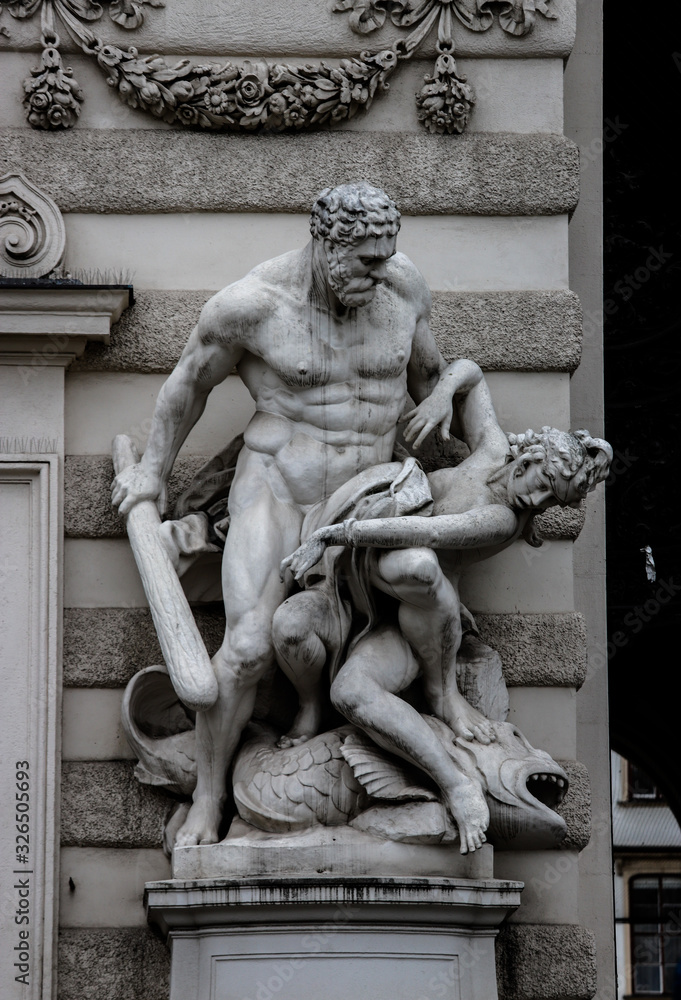 Obraz premium Sculpture of Hercules with a mace fighting another person at the entrance to the Imperial Hofburg Palace.