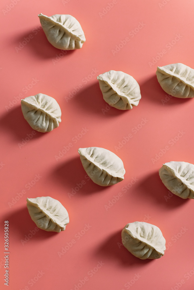 Semi-finished products on a pink background. Top view of manti or dumplings. Pattern Semi-finished products on a pink background. Top view of manti or dumplings. Pattern
