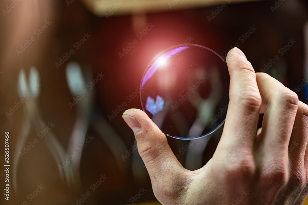 ophthalmologist hands showing a glass lens for spectacles. Blurred background. Ophtalmologist equipment. Vision correction concept. Closeup - obrazy, fototapety, plakaty 