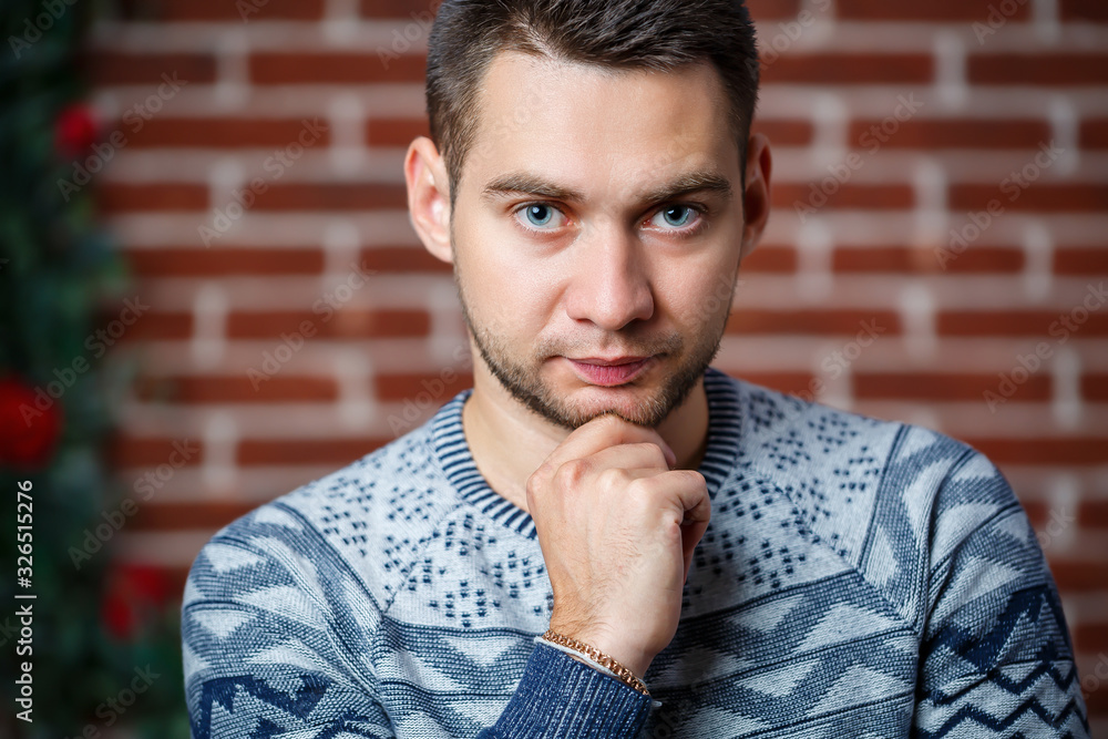 young guy in a sweatshirt against a brick wall young guy in a sweatshirt against a brick wall