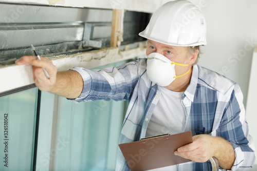 mature man inspecting property wearing face mask photo