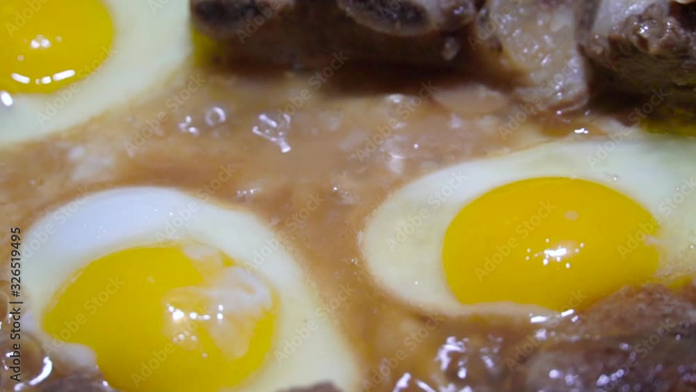 eggs and pork are fried in a pan in fat. The concept of poor and not healthy eating. Slow motion. eggs and pork are fried in a pan in fat. The concept of poor and not healthy eating. Slow motion.