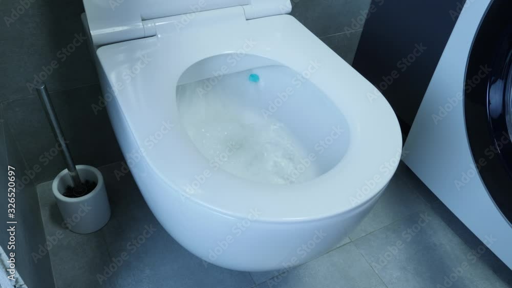 Water flushing down into the toilet bowl in bathroom. Water being