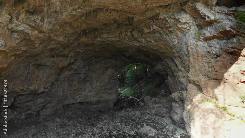 Camera moving forward and entering into a cave in the dense forest. Camera moving forward and entering into a cave in the dense forest.