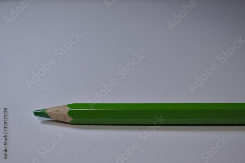 Green pencil sitting on white desk