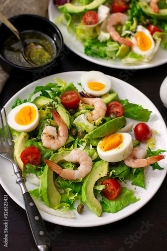 Healthy fresh vegetable salad with shrimps, boiled eggs and avocado