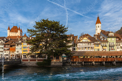 Beautiful panorama view of Thun old town from Aare river side on a sunny autumn day with Central Church, Thun Castle and blue sky cloud in background, Canton of Bern, Switzerland. photo