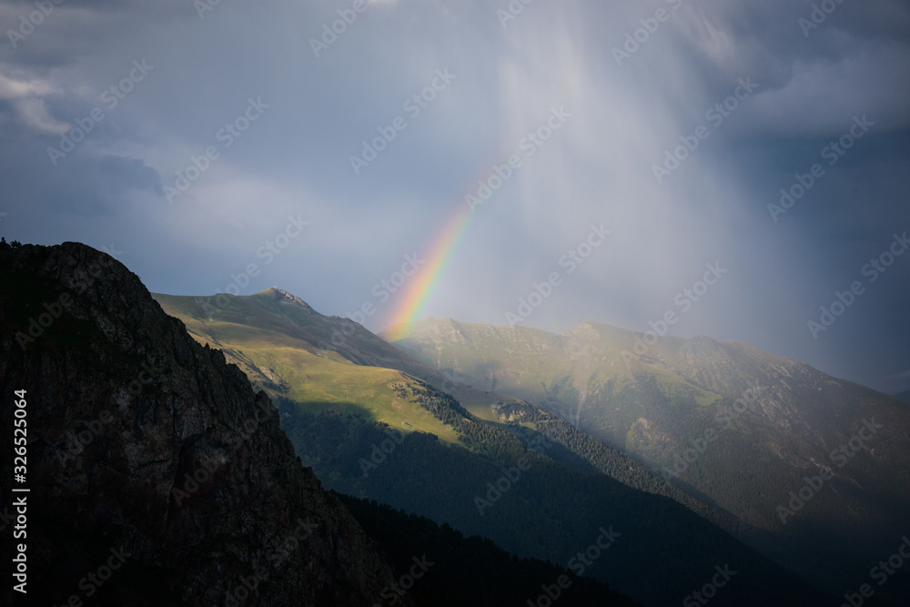 Rainbow in the mountains in cloudy weather