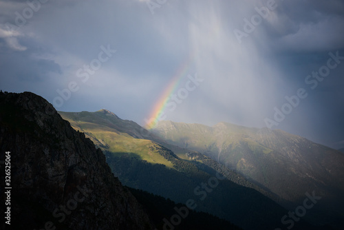 Rainbow in the mountains in cloudy weather