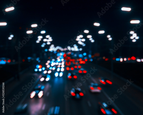Blurred lights of cars in the defocus, against black background.  Colorful lights from cars in defocus, night, outdoor.  Large group of  automobile transport
